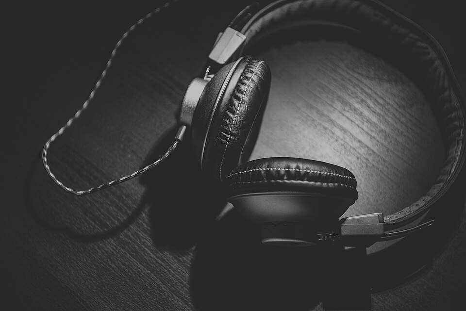 Black and white photo of headphones on a wooden table