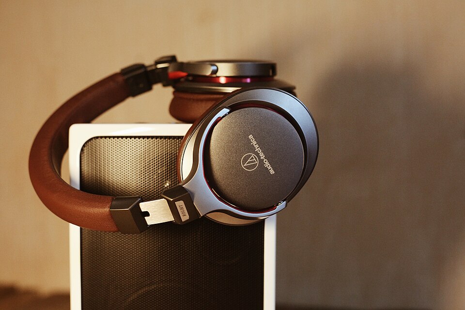 Audio-Technica headphones resting on a speaker