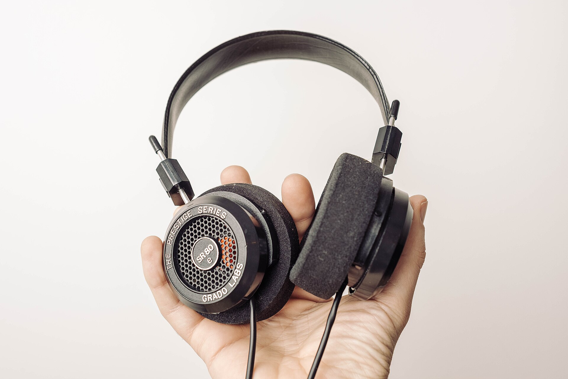 Grado SR80e open-back headphones held in one hand